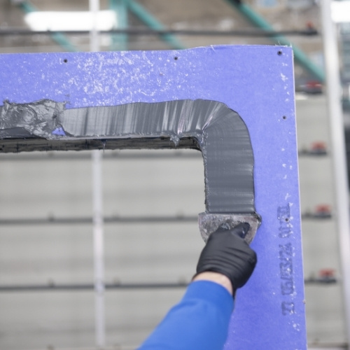 Trowel smoothing ExoAir DualFlash on sheathing corner