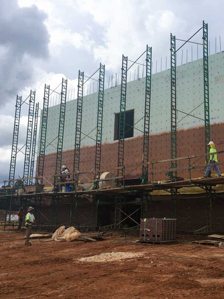 Workers apply Cat 5 barrier to large ICF building using scaffolding