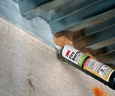 Applying 3M Fire Barrier Silicone Sealant 2000 to joint between concrete and metal deck